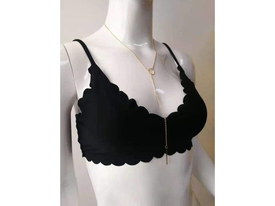 Close-up of a black scalloped bikini top on a mannequin.