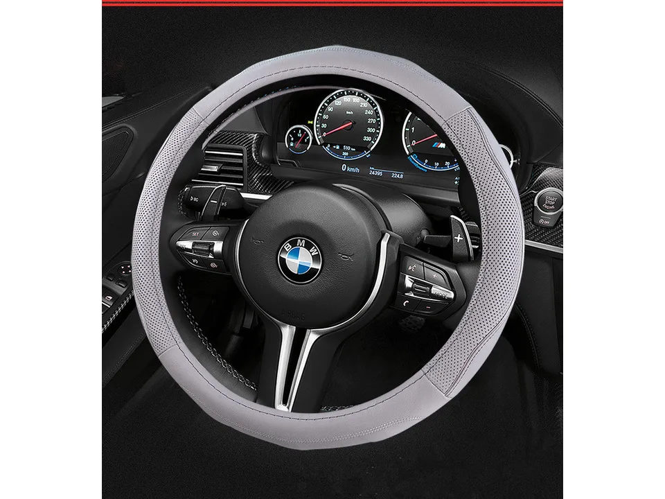 Grey leather steering wheel cover installed on a car steering wheel.