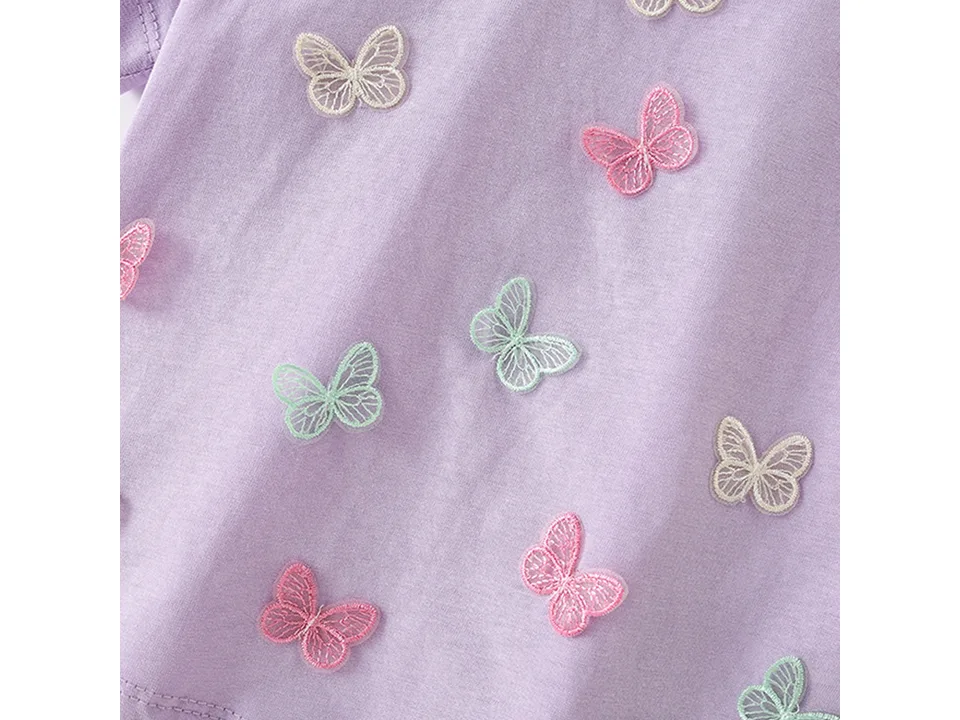 Close-up view of the embroidered butterfly appliques on the purple shirt.