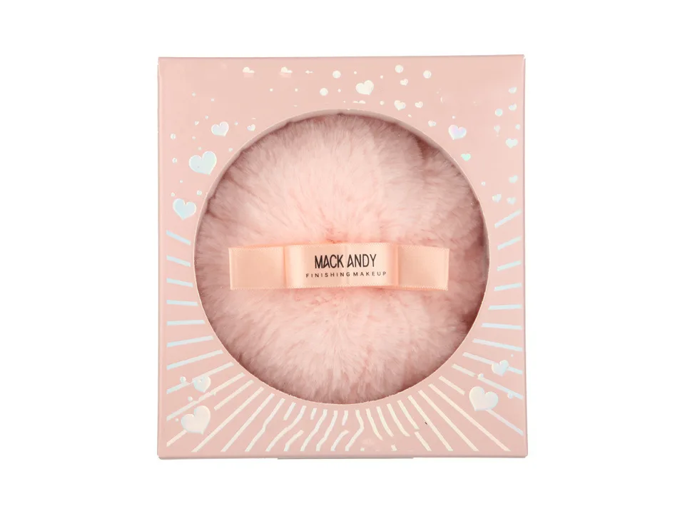A fluffy pink makeup powder puff inside its pink heart-patterned box.
