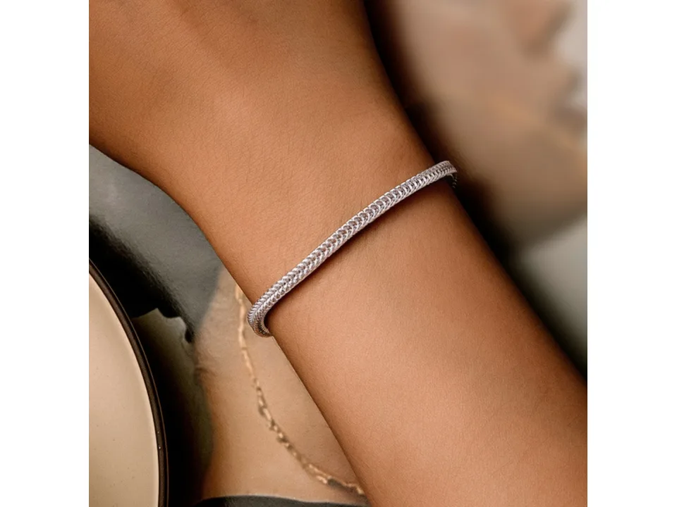 A silver chain bracelet worn on a person's wrist.