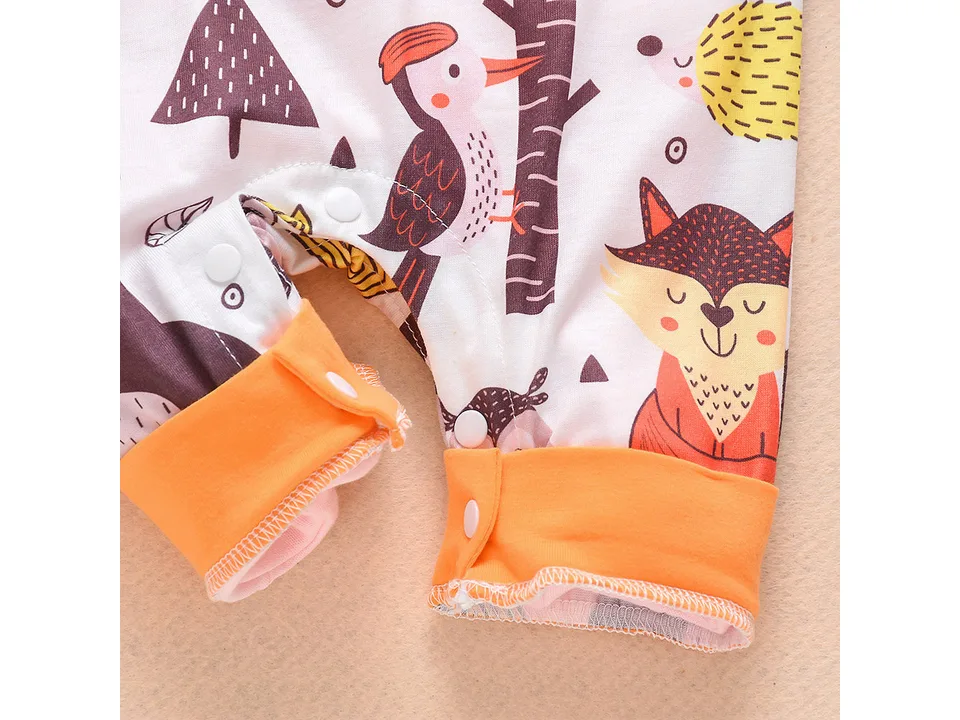 Close-up of the snap buttons and fabric pattern on the infant coveralls.