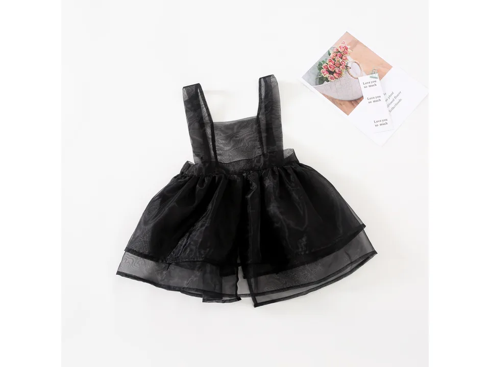 Black gauze overlay dress on a white background