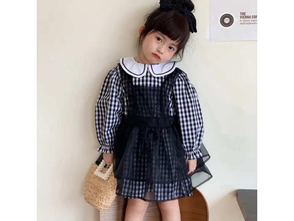 Young girl wearing the plaid dress with a gauze overlay
