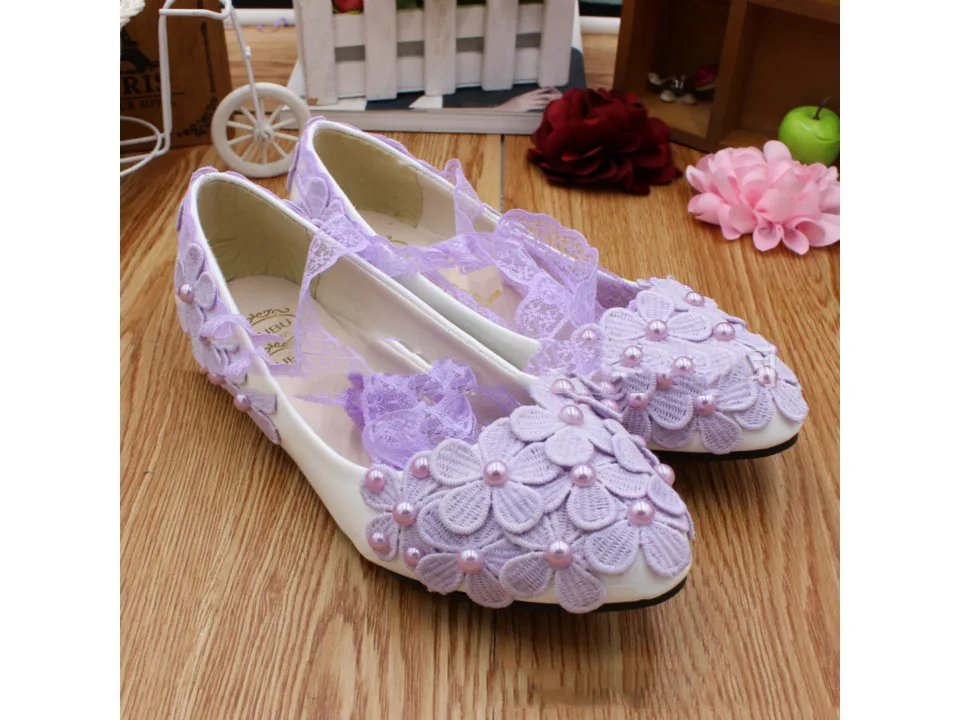 Pair of lavender floral lace-up flats displayed on a wooden surface.