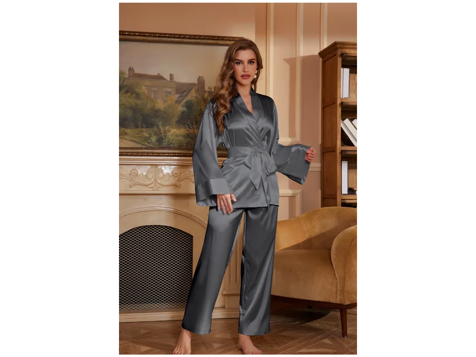 A woman wearing a grey satin pajama set with a long-sleeve top and trousers.
