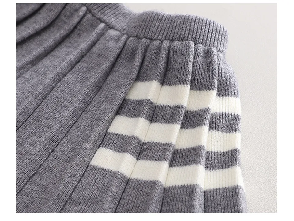 Close-up of the grey and white striped pleated skirt fabric.