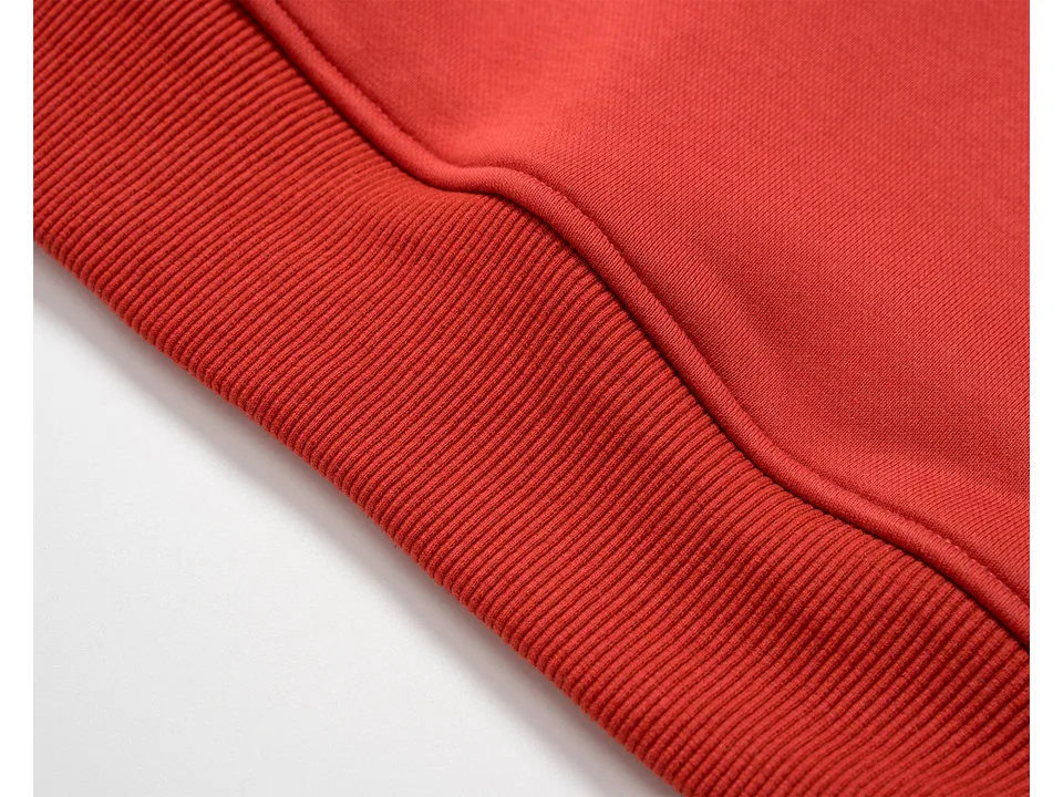 Close-up of the red ribbed hem and fabric texture of the sweatshirt.