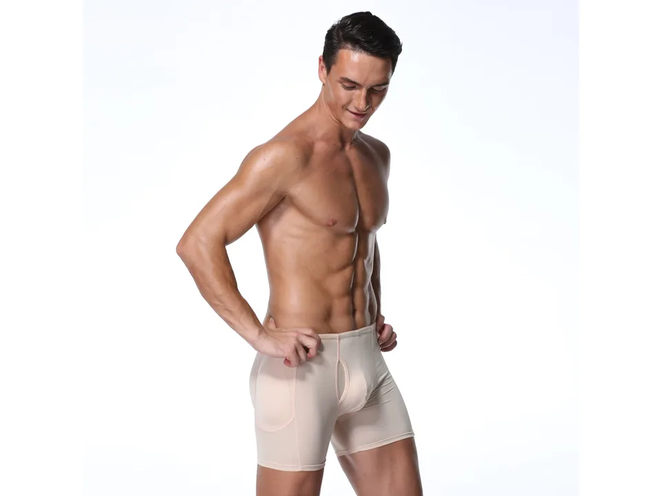 A man wearing beige compression shapewear shorts with hip padding.