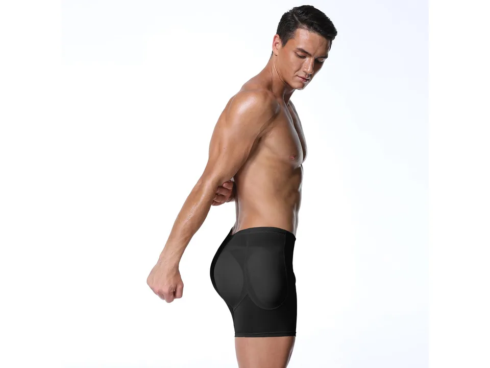 A man wearing black compression shapewear shorts with hip padding, viewed from the side.