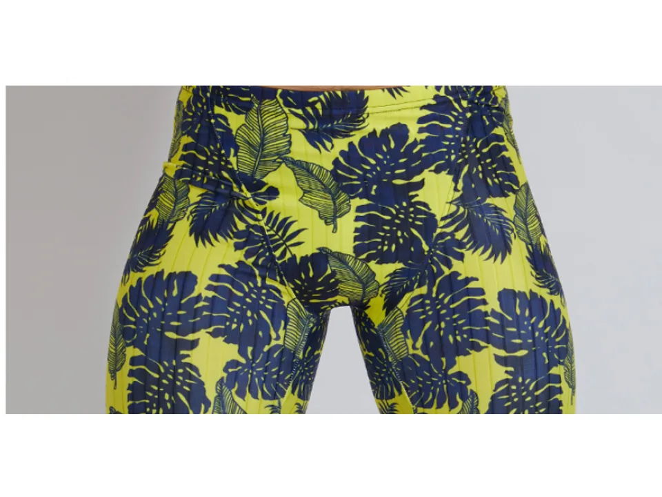 Front view of a man wearing leaf-patterned compression swim jammers.