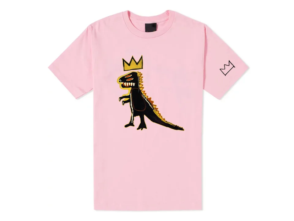 Pink t-shirt with a dinosaur graphic print and a crown logo on the sleeve.