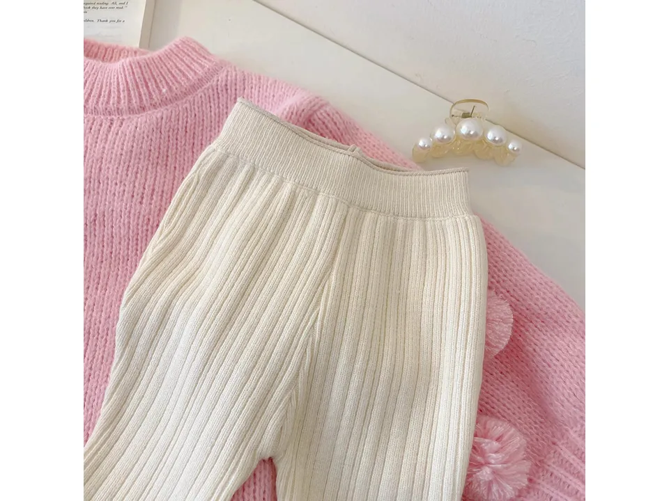 Close-up of the cream ribbed knit flared pants.