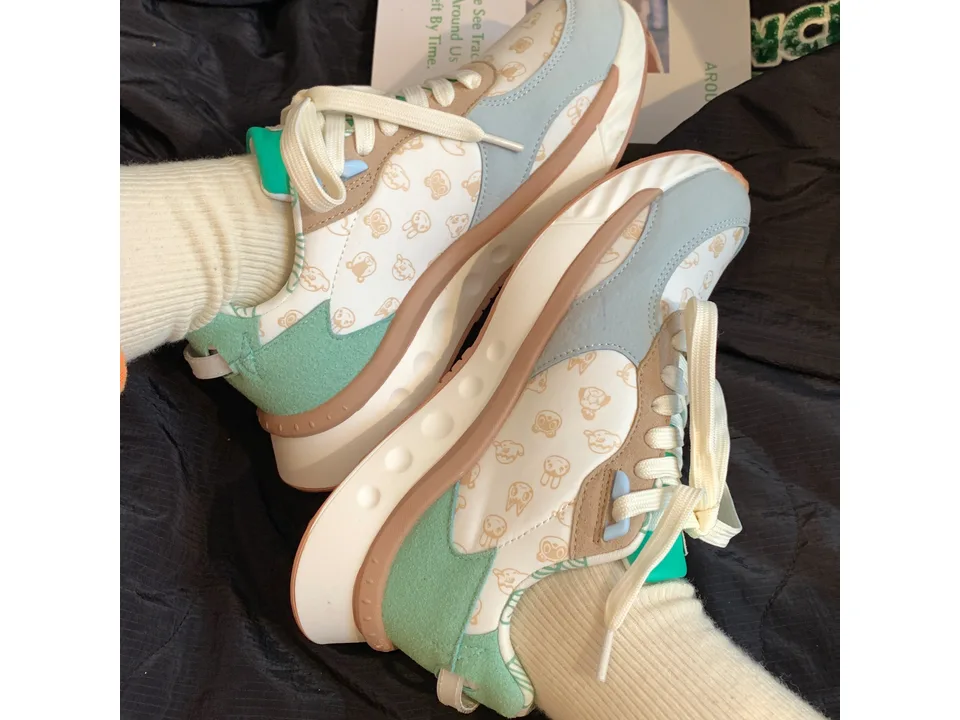 Close-up side view of the macaron-colored sneakers showing the lace-up design and pattern.