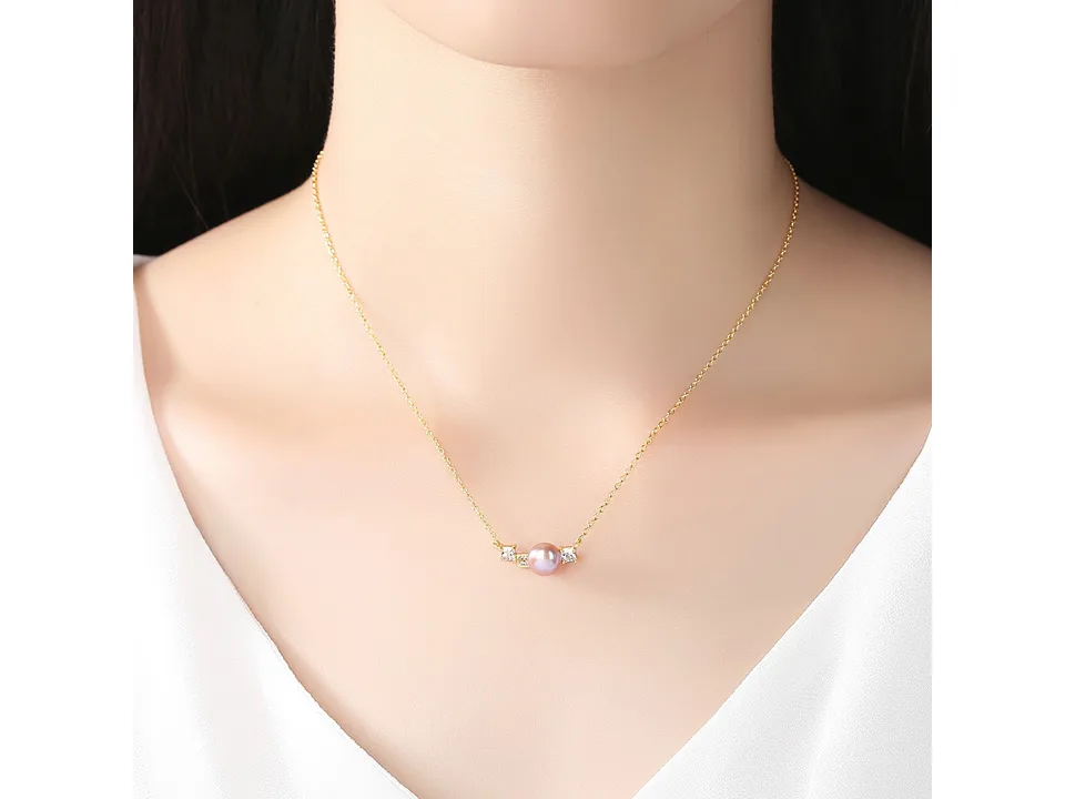 A woman wearing the gold pearl pendant necklace.