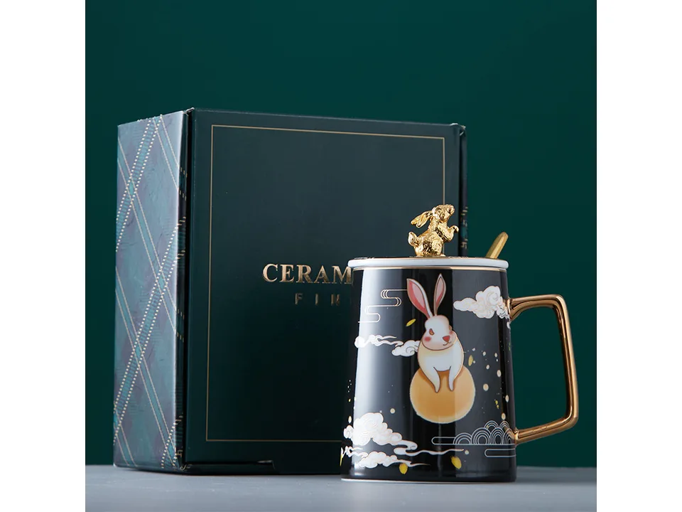 Black ceramic rabbit mug with lid and spoon next to its gift box.