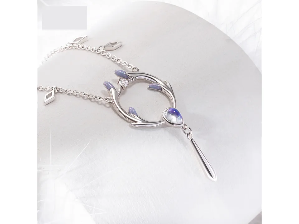 Angled view of the deer antler pendant necklace on a white surface