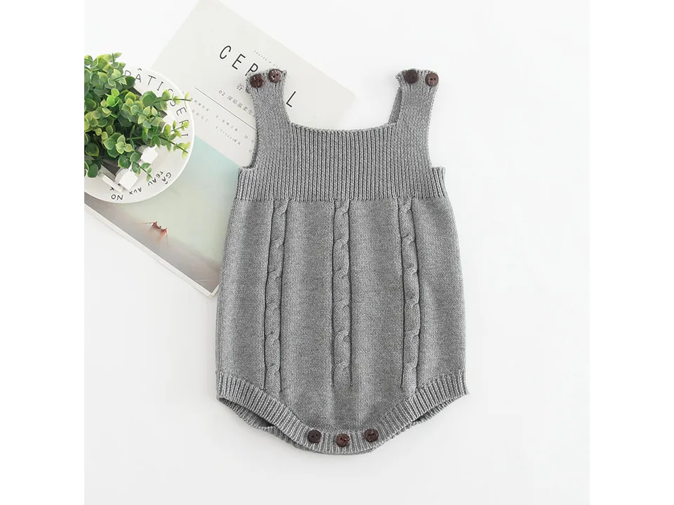 A grey sleeveless baby knit romper with cable knit details.