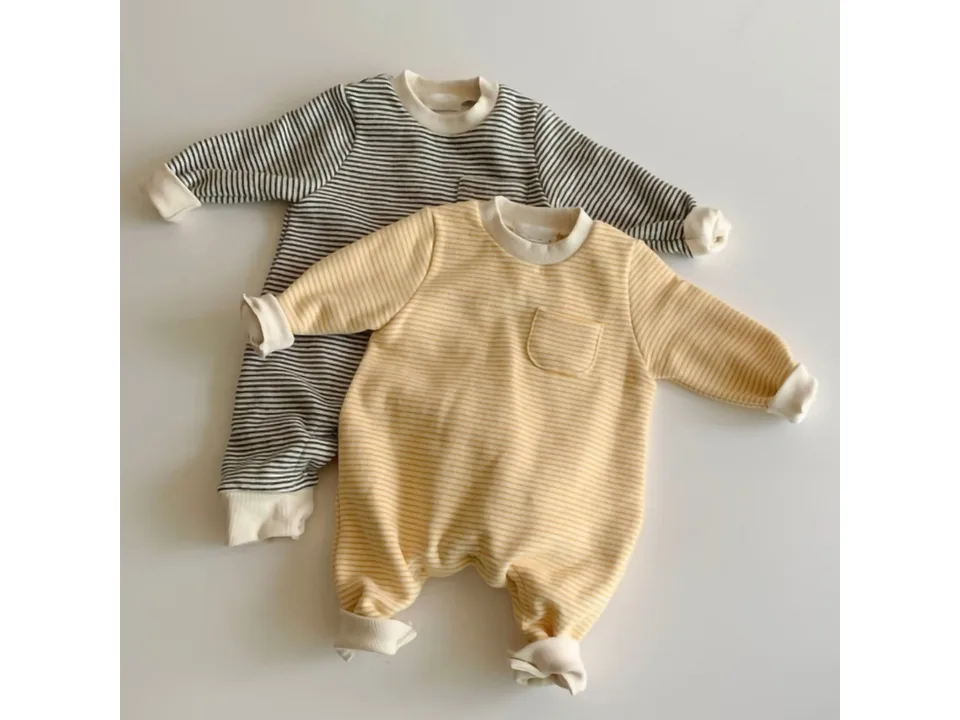 Two baby jumpsuits, one with yellow stripes and one with grey stripes, laid flat.