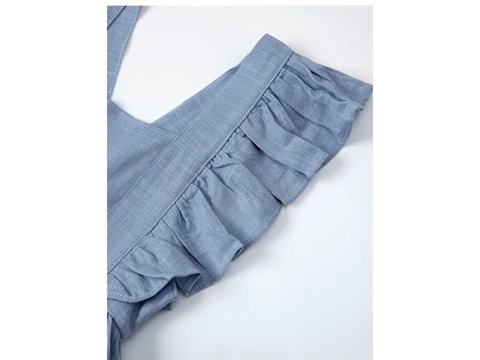 Close-up of the blue dress showing the ruffled strap and fabric texture.