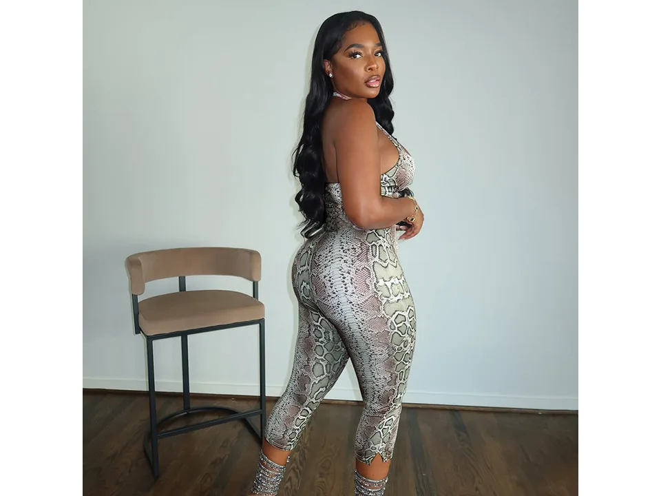 A woman wearing the snake-print jumpsuit, viewed from the side.