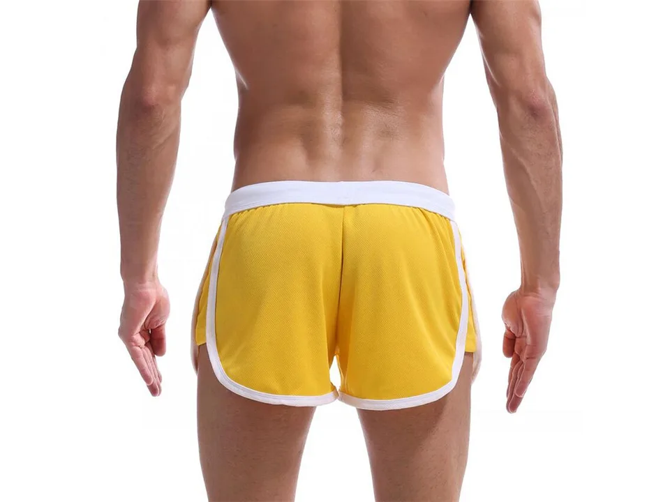 Back view of a man wearing yellow athletic beach shorts.