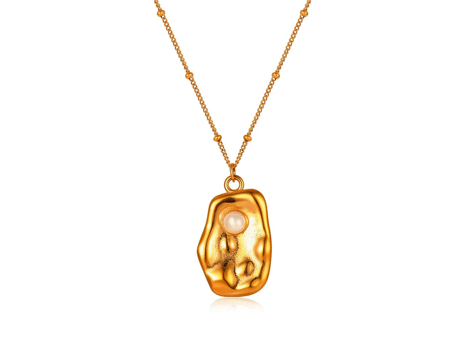 Gold necklace with a textured, irregular pendant featuring a single pearl.