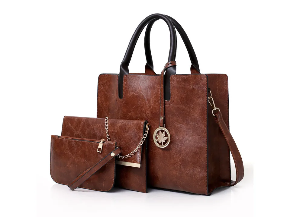Brown handbag set including a tote, a clutch with a chain, and a wristlet.