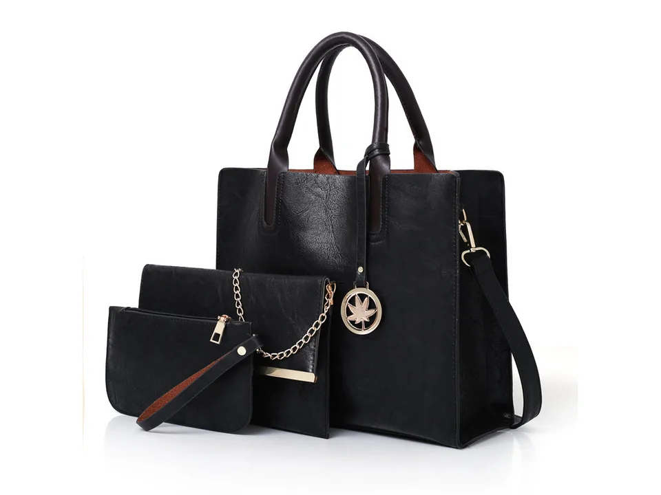Black handbag set including a tote, a clutch with a chain, and a wristlet.