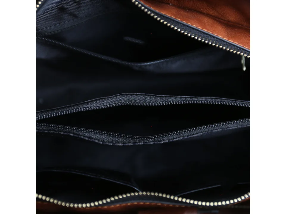 Interior view of the handbag showing multiple zippered compartments and lining.