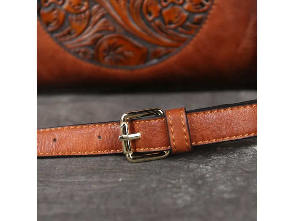 Close-up of the handbag's adjustable leather strap and gold-tone metal buckle.