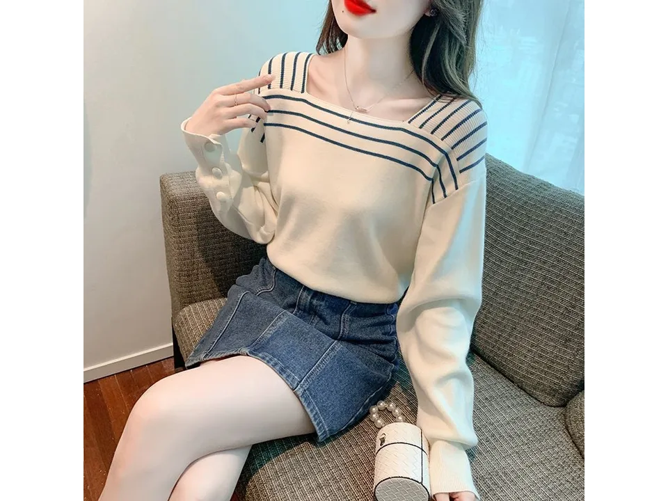 A woman wearing a white square neck long sleeve sweater with blue striped details.