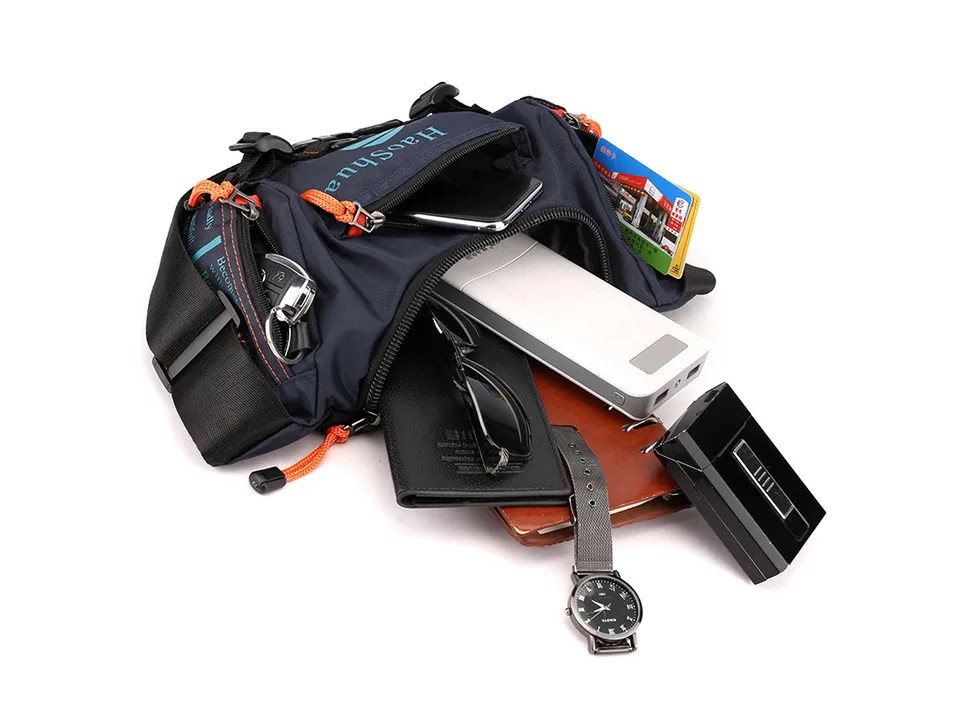 The tactical bag open with various items like a phone, power bank, wallet, and watch inside.
