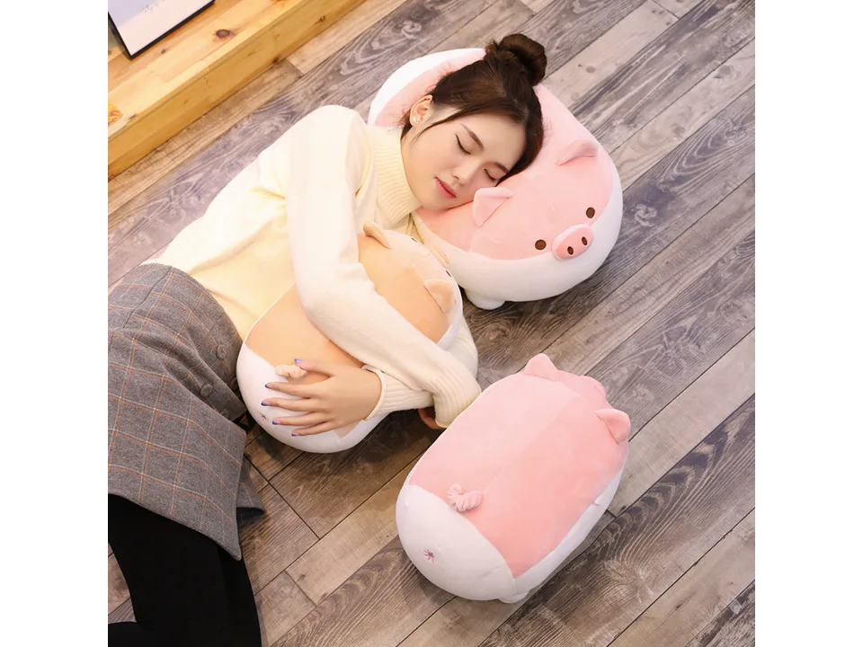 A young woman sleeping while hugging a pig plush pillow.