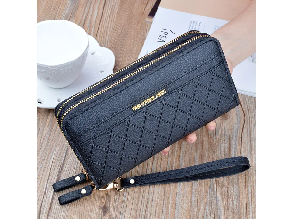 Black quilted long wallet with wrist strap held in hand