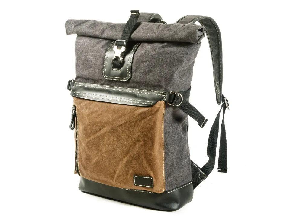 Side angle view of the grey and brown roll-top backpack.