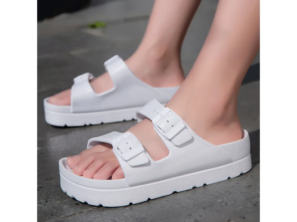 White platform slide sandals worn on feet