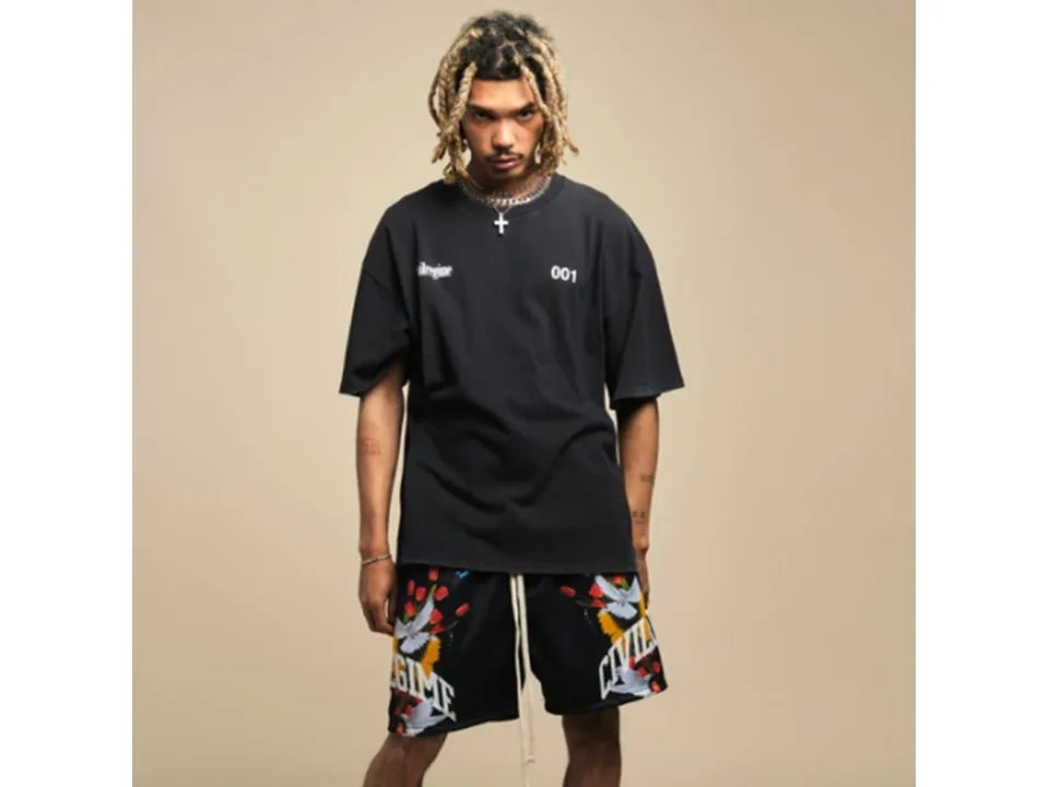 Model wearing black athletic shorts with graphic print.