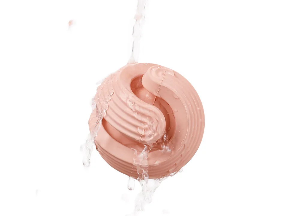 Pink dog chew toy being rinsed under running water