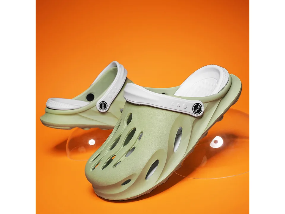 Light green EVA clog slipper with white strap on an orange background.