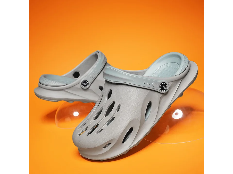 Grey EVA clog slipper with adjustable strap on an orange background.