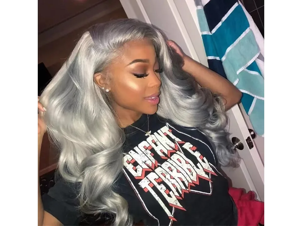 A woman wearing a long, wavy, silver-grey lace front wig.