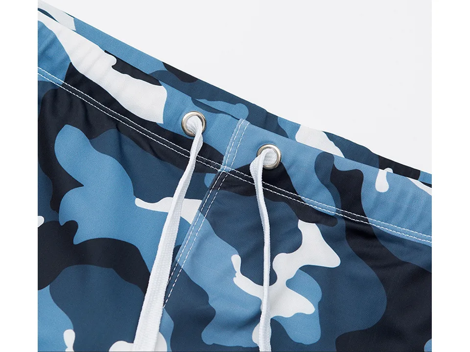 Close-up of the waistband and white drawstring on blue camouflage swim trunks.