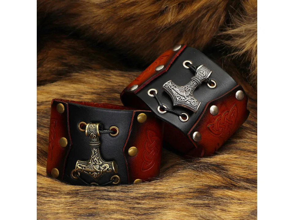Two leather Viking bracelets with Thor's hammer pendants, one with gold and one with silver hardware.