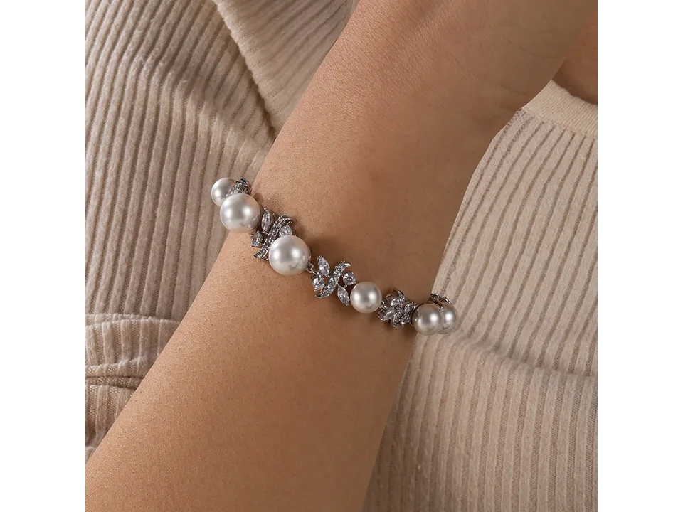 A pearl and zircon bracelet worn on a woman's wrist.