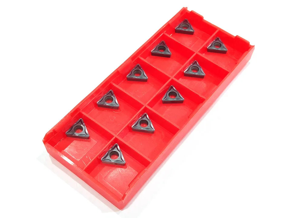 A red plastic storage case containing multiple triangular CNC lathe cutting blades.