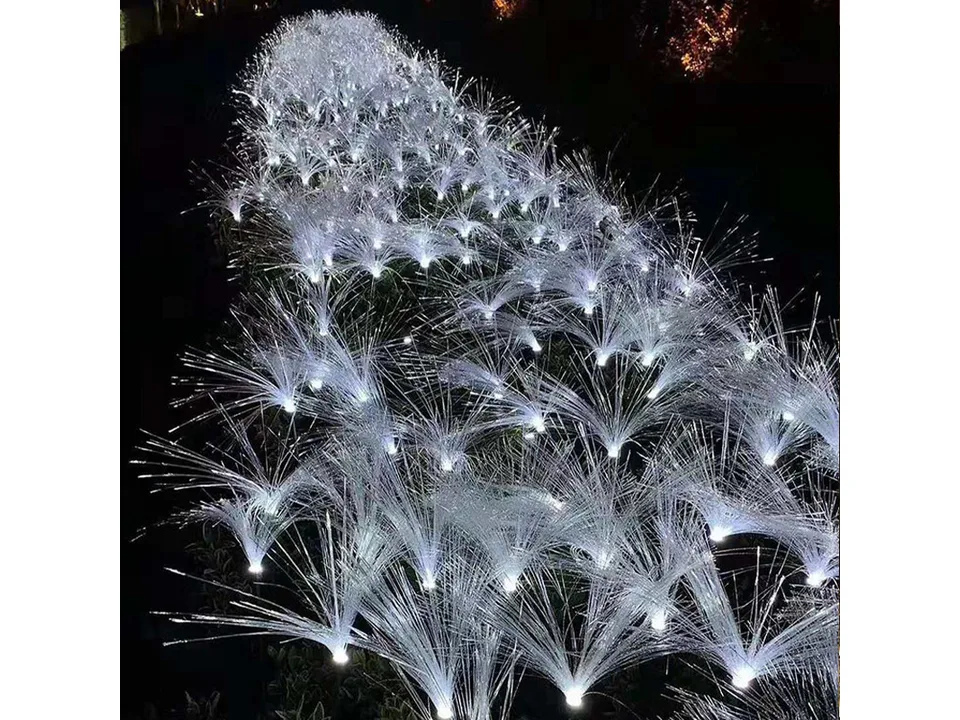 Close-up of several fiber optic lights glowing white in the dark.