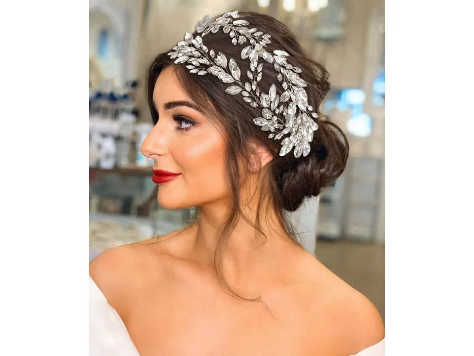 A bride wearing a sparkling rhinestone leaf-patterned hairband.