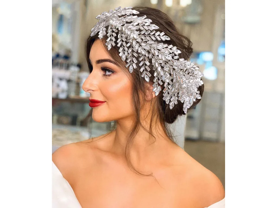 Close-up of a bride wearing a detailed crystal bridal headpiece.