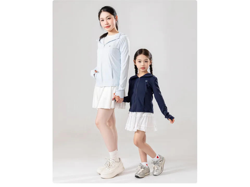 A woman and a young girl wearing lightweight outdoor jackets.
